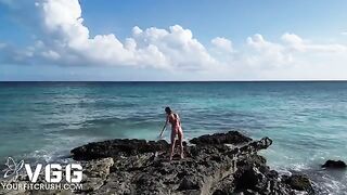 A petite girl is naked on the beach
