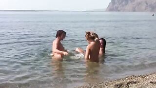 Three bare girls on the public beach with no clothes