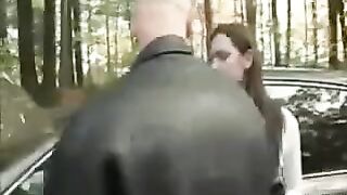 A chick is having fun on the car’s bonnet while her boyfriend is recording