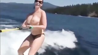 A sexy girl is water skiing without any clothes on her body