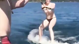 A sexy girl is water skiing without any clothes on her body