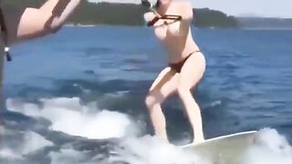 A sexy girl is water skiing without any clothes on her body