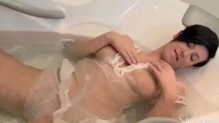 A lonely brunette woman caresses herself in the shower stream