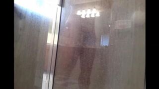 A man washes his body in the shower, unaware of being filmed