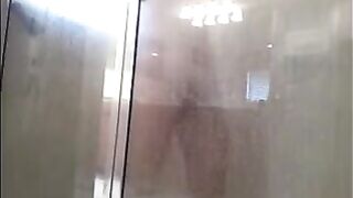 A man washes his body in the shower, unaware of being filmed