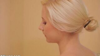 The girl plays with herself with a brush in her hand in the bathroom