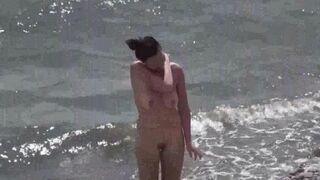 Nudist couple enjoy each other on the beach