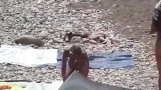 Nudist couple enjoy each other on the beach