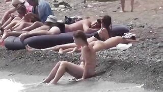 Nudist couple enjoy each other on the beach