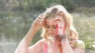 A hot blonde is indulging in solo pleasure by the lake