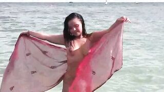 A woman has a bath in the sea naked