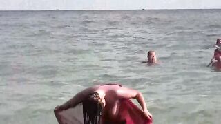 A woman has a bath in the sea naked