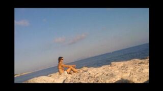 A naked girl basks in the sun’s rays on a sunny afternoon