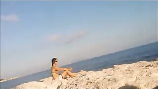 A naked girl basks in the sun’s rays on a sunny afternoon