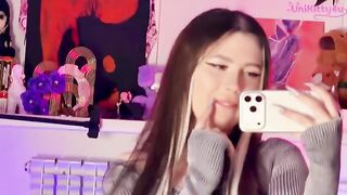 A girl plays with a dildo in front of the mirror, showcasing her alternative style