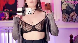 A girl plays with a dildo in front of the mirror, showcasing her alternative style